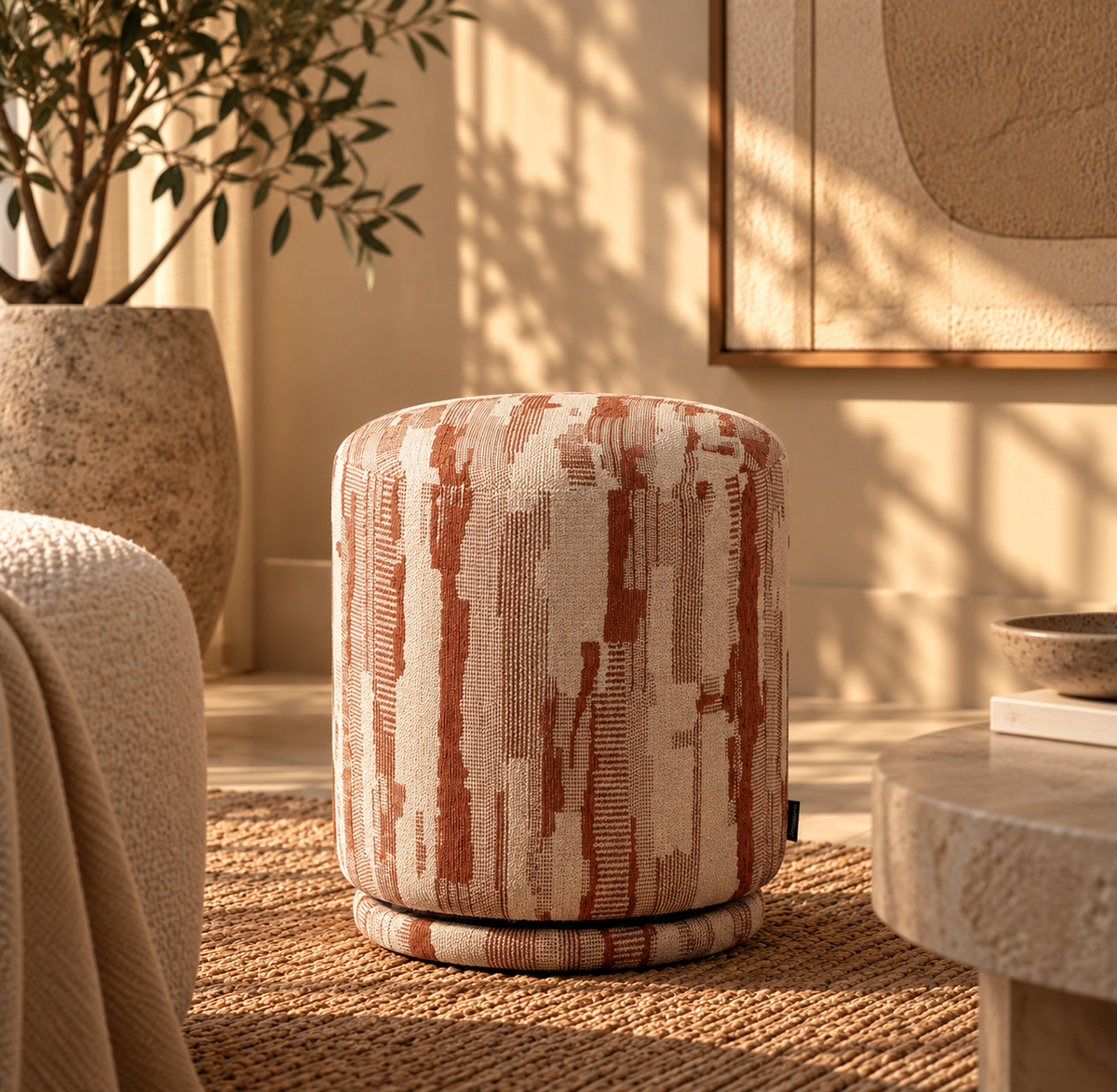 Pouf Isabelle in Creme und Terracotta mit grafischem Muster in einem warmen, minimalistischen Interior.