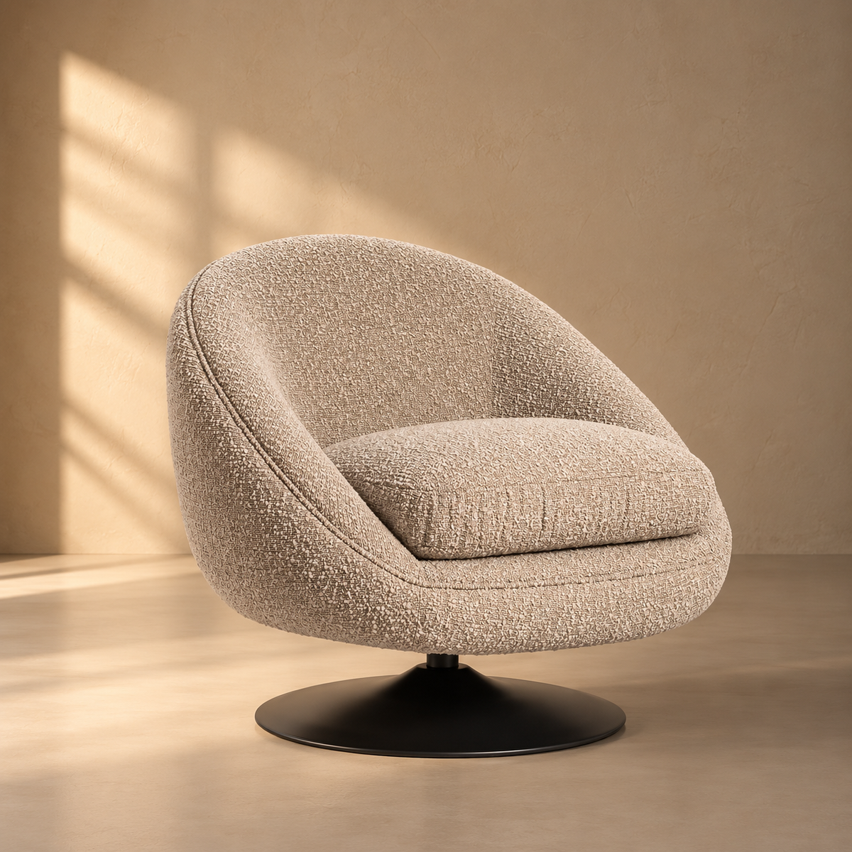 Sessel Martin mit weich gerundeter, geschlossener Sitzschale, großzügigem Sitzpolster und strukturiertem Bezug in hellem Taupe. Der schwarze Tellerfuß setzt einen klaren Kontrast und unterstreicht die moderne, skulpturale Form von Interior Boutique