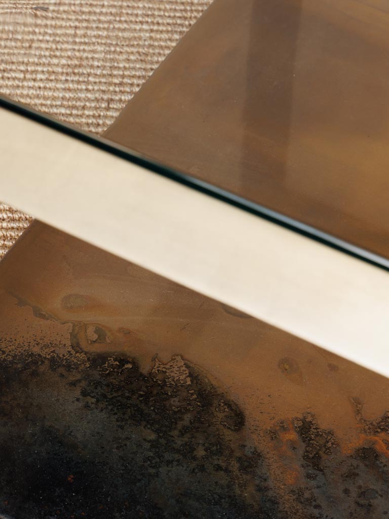 Detailaufnahme des Couchtisches Baptiste aus braunem Eisen und Glas, die die feine Verarbeitung und elegante Textur des Materials zeigt, ideal für kunstvolle Wohnzimmergestaltung.