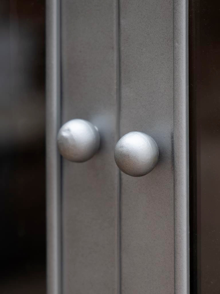 Detailaufnahme des Schrankes Boris, gefertigt aus grau und gunmetal Eisen sowie Messing, die die feine Verarbeitung und robuste Textur zeigt. Ideal für modernes Interieur mit elegantem Touch