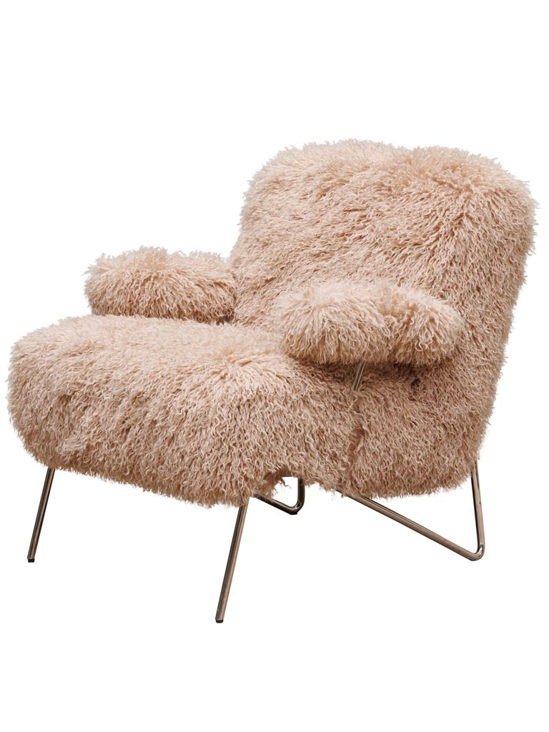 Matheo Loungesessel mit beigefarbenem, langflorigem Bezug und filigranem Metallgestell in warmem Interior-Boutique-Studio-Setting.