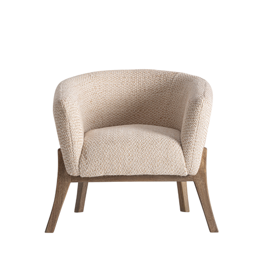 Stuhl Ruben mit gerundeter Sitzschale, strukturiertem Bezug in Creme und ausgestellten Holzbeinen im ruhigen Produktsetting von Interior Boutique.