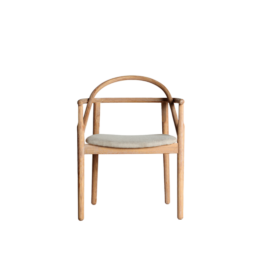 Stuhl Theodor aus hellem Holz mit geschwungener Rückenlehne und heller Sitzpolsterung im warmen, minimalistischen Interior Boutique Studio-Setting